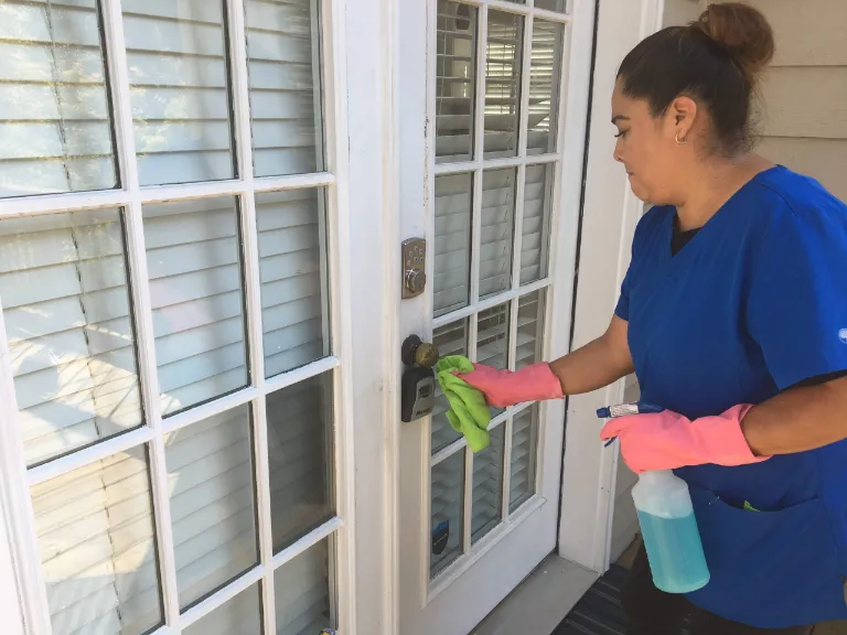 Lady cleaning the door of a house