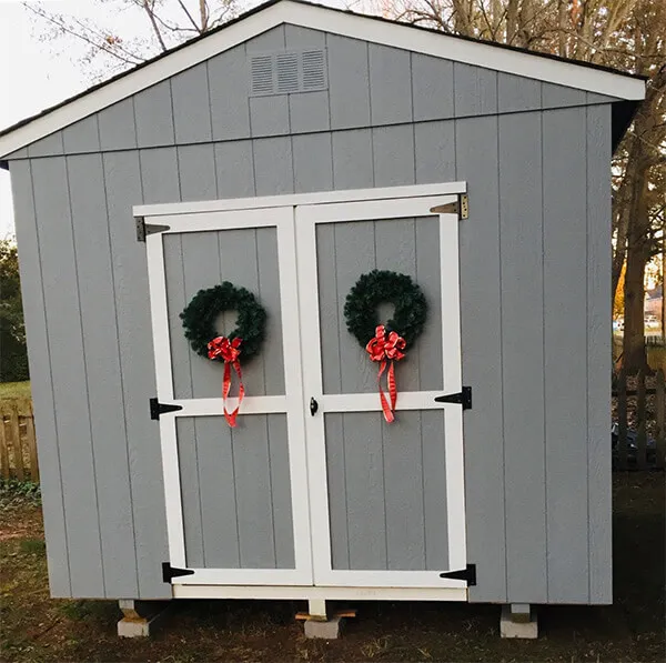 outside cabin with doors decorated with christmas crowns