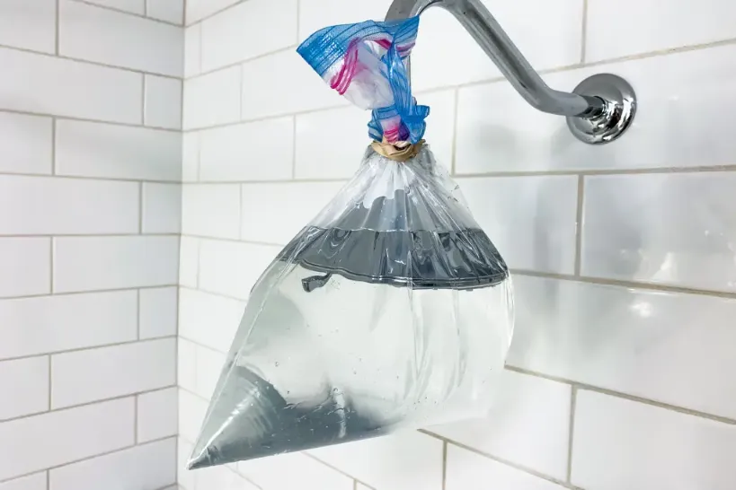 plastic sleeve full of water tied to a showerhead 