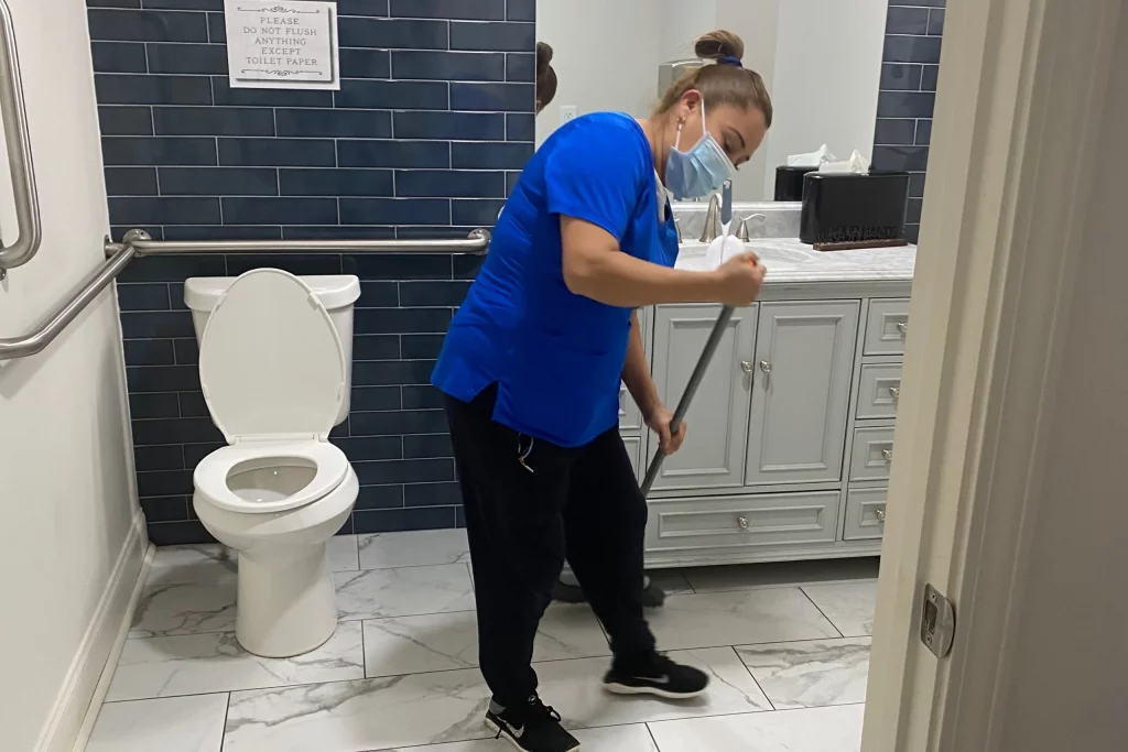 clean tu casa team mmeber cleaning office restroom
