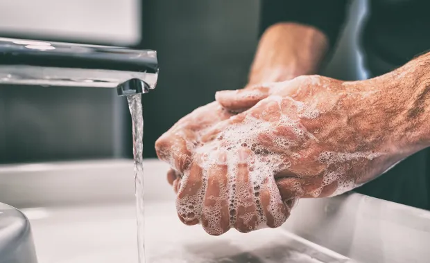 hero person washing hand with soap under a tap